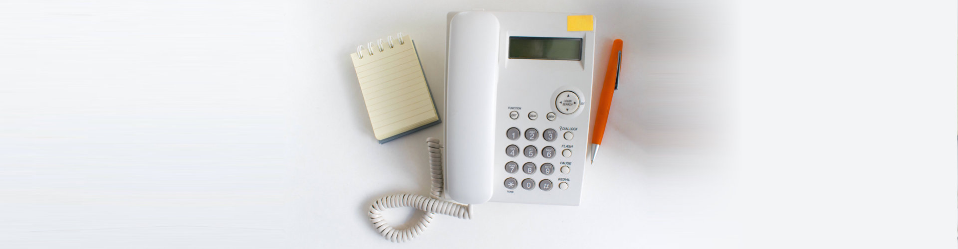 a white telephone and a pen